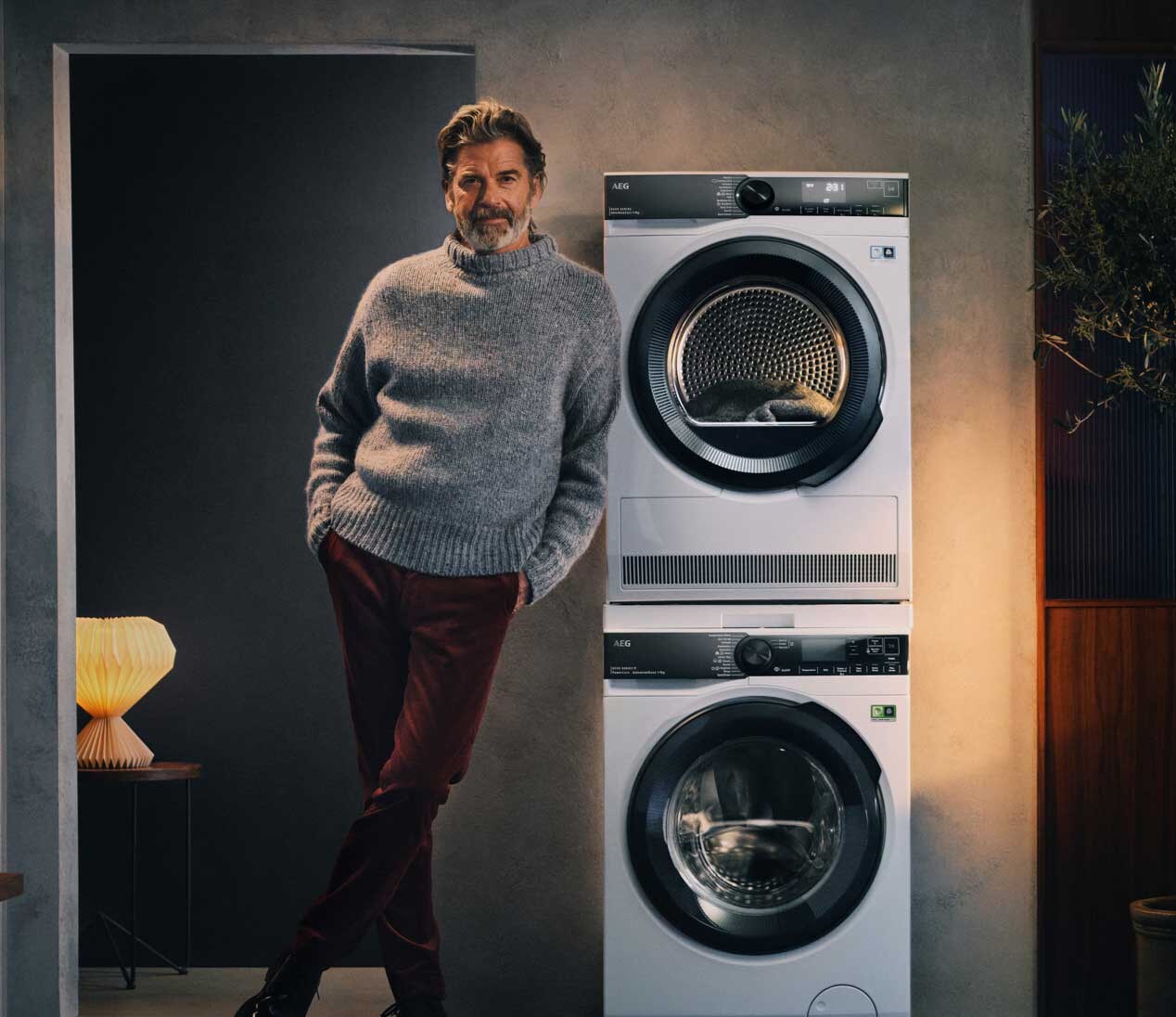 man naast wasmachine en droogkast